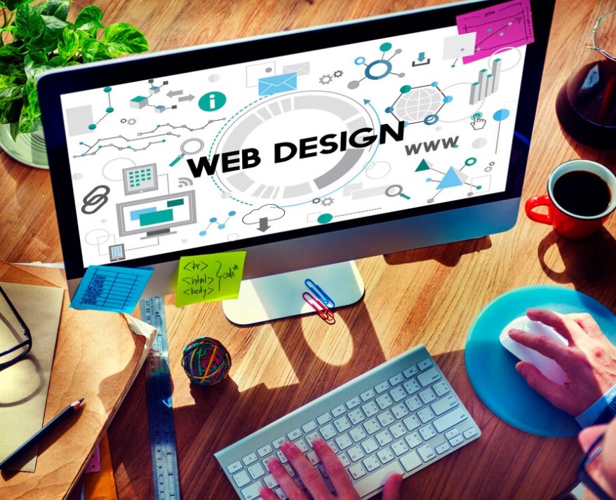 web design technology concept: a person using a keyboard and a mouse in front of a PC monitor, with a web design wallpaper on it