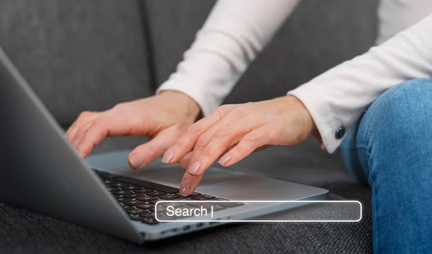 A man is working on a computer and the search bar